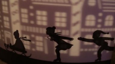 Bir kızak ve projeksiyon şehrin üzerinde paten çocukların dekoratif siluetleri