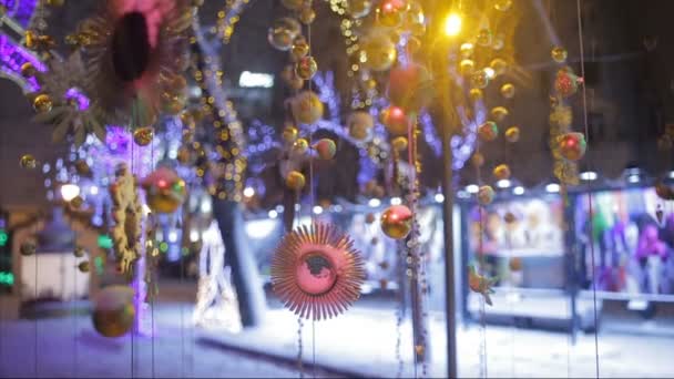 Schnee fällt auf Weihnachtsspielzeug und Dekoration auf der Straße — Stockvideo