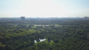 Güneşli bir gün, ufukta park, lake ve kentsel yapılar havadan görünümü