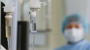 Doktor ameliyatı ameliyathanede. Damlalık.