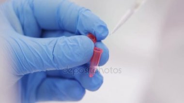 Biotechnologist sıvı analizi için tüp içine dökülen. Portre