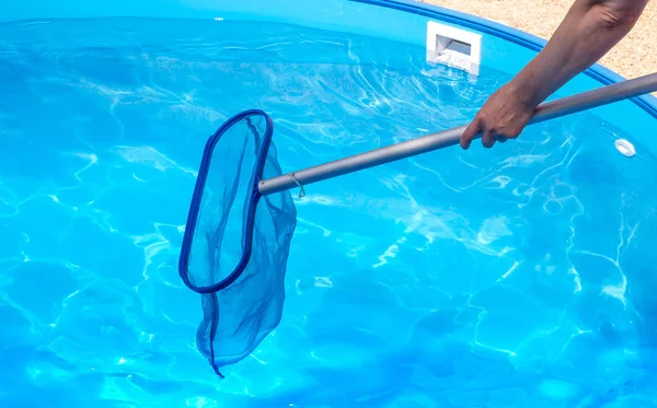 Woman hands cleaning pool