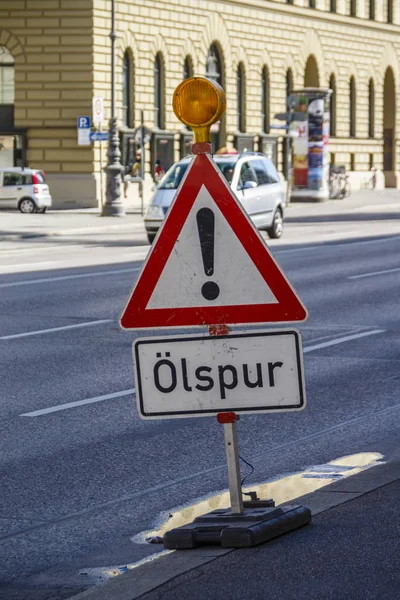 Varningstecken om olja på vägen i München, Tyskland, 2015 — Stockfoto