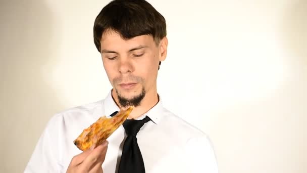 Man in de jas en stropdas eet pizza — Stockvideo