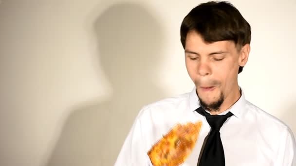 Молодой человек ест пиццу и показывает большой палец вверх — стоковое видео