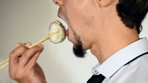 Homem barbudo comendo sushi com pauzinhos e mostra os polegares para cima — Vídeo de Stock