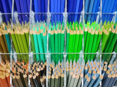 Bir sanat mağazasında tezgahın üzerinde renkli kalemler. Renkli kalemlerin geniş seti.