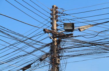 Bir sokak lambası mavi gökyüzü arka plan üzerinde farklı yönlere çalıştırmak pek çok elektrik kablo ile