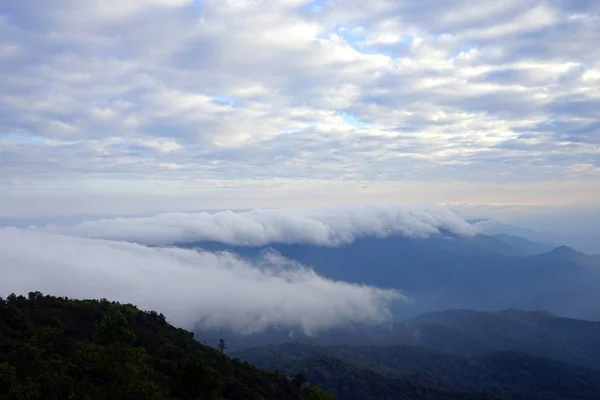Paysage de montagne avec vague de brouillard et ciel nuageux foncé sur le t — Photo