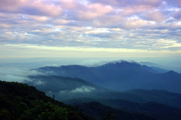 Paysage de montagne avec vague de brouillard et ciel nuageux foncé sur le t — Photo