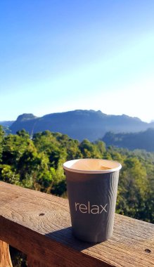 Kağıt kahve Kupası ahşap masa ve açık dağ ve sunl