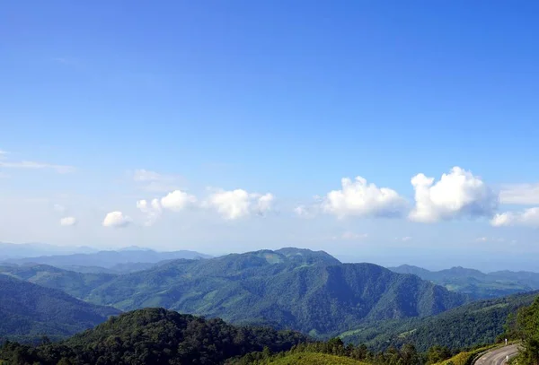 Paysage montagneux vert contre ciel bleu clair avec nuages — Photo