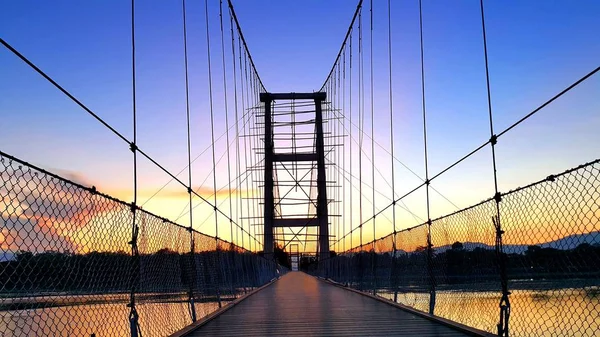 Ponte suspensa em construção durante o belo pôr do sol . — Fotografia de Stock
