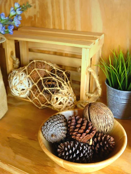 Conos de pino en cuenco de madera decorado en estante — Foto de Stock