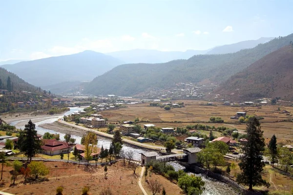 Ponte sul fiume con case tradizionali in stile bhutanese — Foto Stock