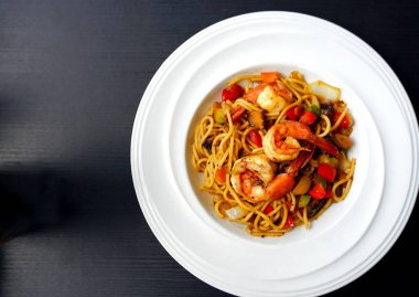 Tay baharatlı bitkisel sos ve karides beyaz tabakta spagetti