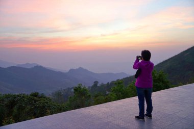 Güzel mou manzaraya bakarak kamera tutarak fotoğrafçı