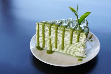 Yeşil çay krep pastasından beyaz plaka üzerinde