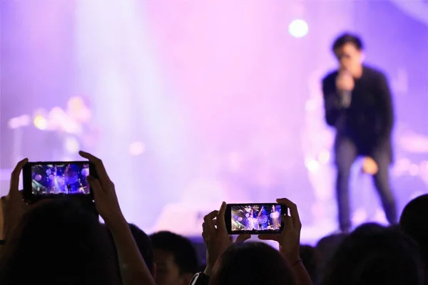 İnsanlar akıllı telefonlarını holding ve f konser fotoğraf çekimi