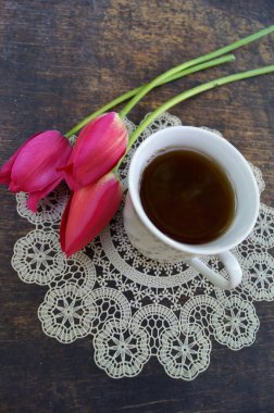 Çay bardağı, Lale çiçek, ahşap arka plan üzerinde. Bahar kompozisyon.