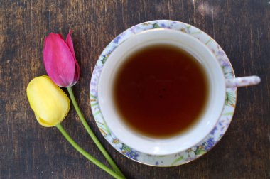 Çay bardağı, Lale çiçek, ahşap arka plan üzerinde. Bahar kompozisyon.