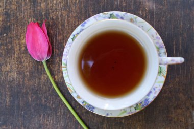 Çay bardağı, Lale çiçek, ahşap arka plan üzerinde. Bahar kompozisyon.