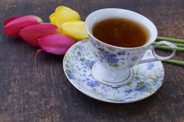 Çay bardağı, Lale çiçek, ahşap arka plan üzerinde. Bahar kompozisyon.