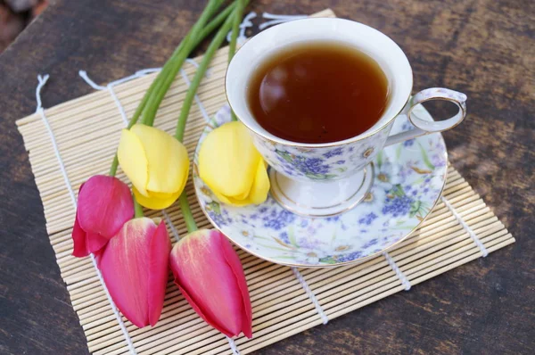 Filiżanka do herbaty, kwiat tulip, na tle drewnianych. Kompozycja wiosna. — Zdjęcie stockowe