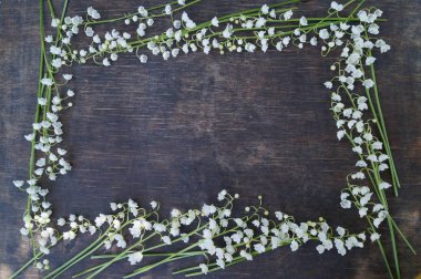 Çerçeve beyaz çiçek, ahşap arka plan üzerinde vadideki zambak