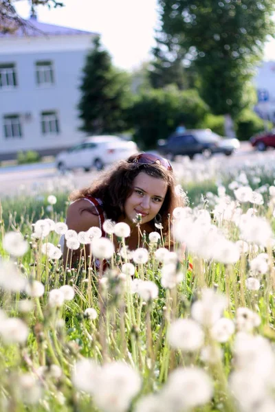 Молода жінка в полі з багатьма кульбабами — стокове фото