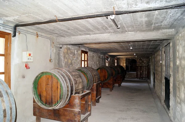 Barricas de vino apiladas en la antigua bodega de la bodega. —  Fotos de Stock