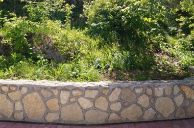 Taş duvar ile yeşil alan. Doku doğa. Metin, afiş, etiketi için arka plan.