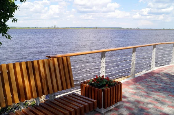 Een bankje of een plek om te ontspannen in de buurt van een rivier, een vijver. Moderne stijl. — Stockfoto