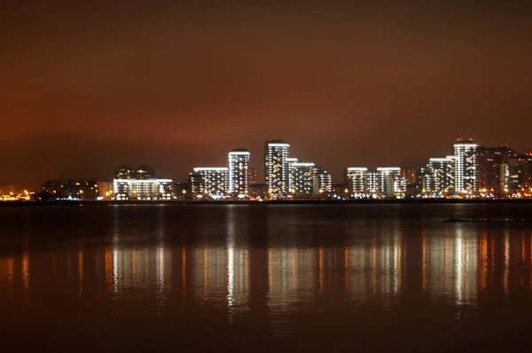 Brilhantemente iluminada à noite a cidade de Kazan, refletida nas águas do rio Kazanka, Rússia . — Fotografia de Stock