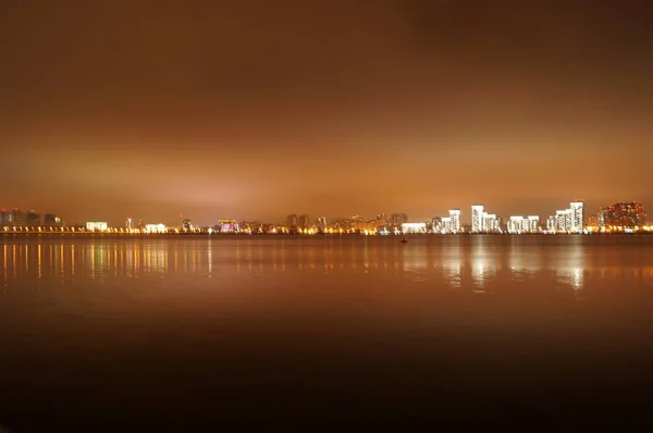 Brilhantemente iluminada à noite a cidade de Kazan, refletida nas águas do rio Kazanka, Rússia . — Fotografia de Stock