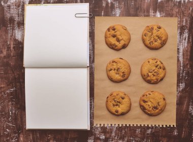 Not Defteri, kurabiye ve kraft kağıt kahverengi zemin üzerinde beyaz açıldı. Vintage mockup metin için yer ile