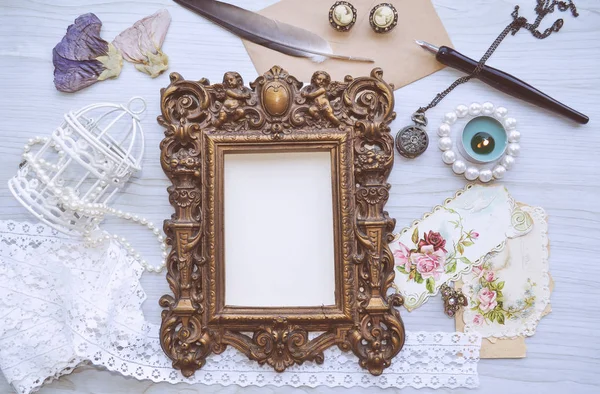 Vintage mockup. Vintage frame with little angels, candle, lace, pearls, vintage earrings, dried flowers, old postcards, pocket watch
