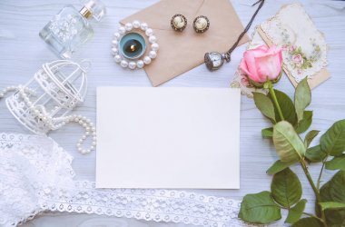 Vintage mockup. Boş kağıt ve zarf, pembe Gül, mum, dantel, inci, anahtar, vintage küpe, anahtar, eski kartpostallar. Düğün davetiyesi