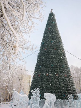 Kasaba meydanında çelenk ve balonlar ile süslenmiş Noel ağacı