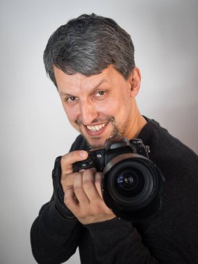 adam kamera elinde yaygın olarak dikkat çeken gülümsüyor ve bir resim çekmek için hazır tutar