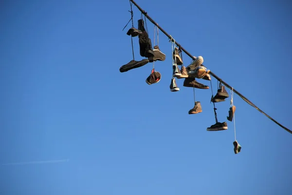 Mavi gökyüzüne karşı bir ip asılı ayakkabı