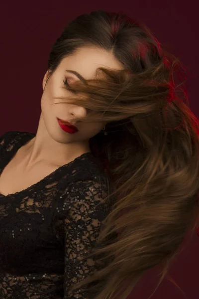 Kapalı gözlerle ve uçan siyah elbiseli genç güzel kadın