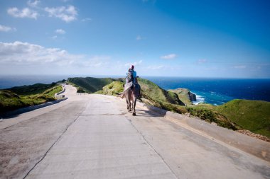 Filipinler, Batanes tepelerinde Carabao 'suna binen çiftçi.