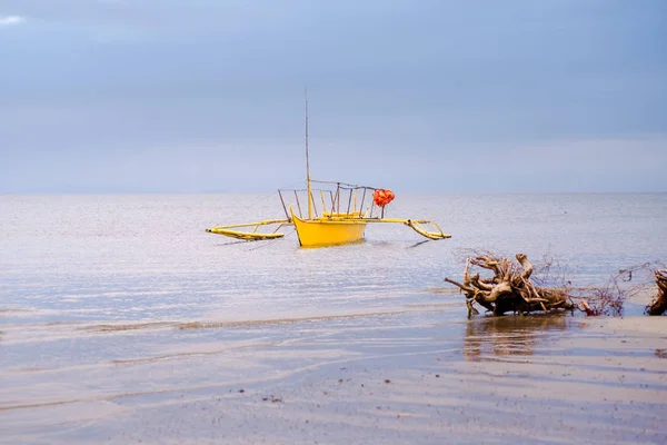 Yellow boat anchored at the shore