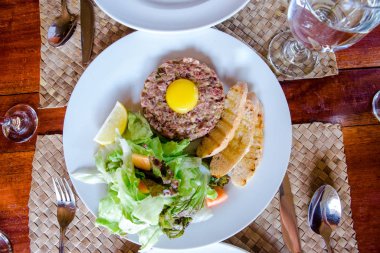 Biftek ve taze organik sebzeler yerel masada servis ediliyor.