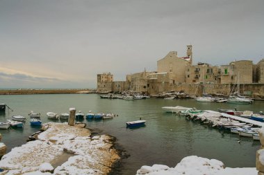 Deniz manzarası Winter.Giovinazzo'nın liman. Italy(Apulia). Görünüm kar kaplı eski şehir: Apulia Romanesk tarzı Santa Maria Assunta Katedrali üzerinde arka plan.