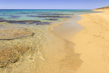 Yaz plaj. Sahil kumlu koyları ve sivri kayalıklar gerçekten açık ve kristal denize bakan düşündüren bir münavebe ile karakterizedir.