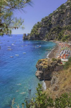 Yaz sescape: Amalfi Coast (Costiera Amalfitana). İtalya: Positano Seaside (Campania) en iyi plajları. Fornillo Plajı uçurumun içinde ayarla: arka plan bir gözetleme kulesi. 