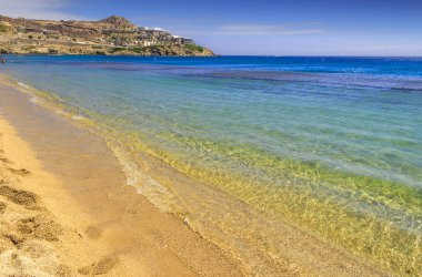 Yaz. Mykonos: Paradise beach (Kalamopodi), Yunanistan. Kristal berraklığında su ve mavi gökyüzü güneşli. Mykonos kesinlikle en ünlü plaj cennettir: ince kum ve zümrüt yeşil su.