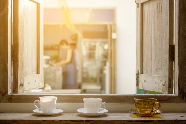 Cangkir kopi pada panel jendela kayu terbuka dengan pemandangan luar ruangan — Stok Foto